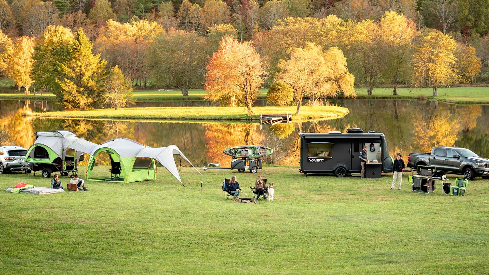 Family camping with SylvanSport gear near a lake in fall.
