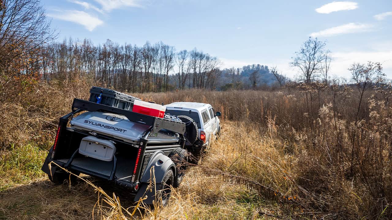 Off-road trailer with DuraDeck platform and SylvanSport gear in nature.