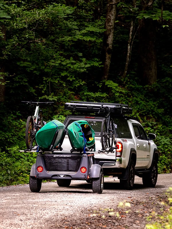 Compact kayak trailer with gear storage for outdoor enthusiasts.