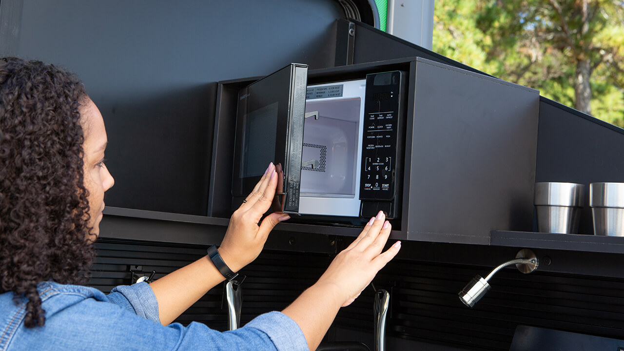 woman using microwave inside VAST kitchen